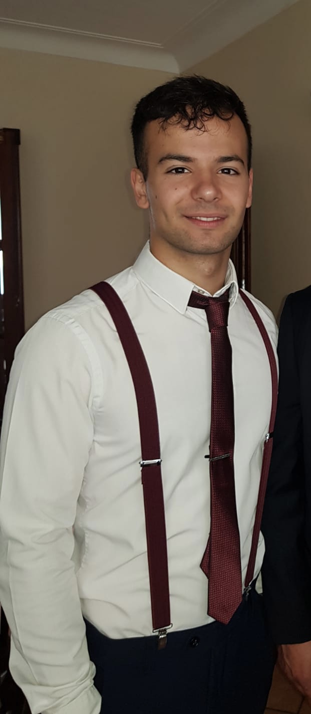 An indoor picure of Giovanni Grasso in a white shirt with red tie & braces